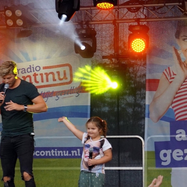 Tim Douwsma met een kleine fan op het podium van Radio Continu